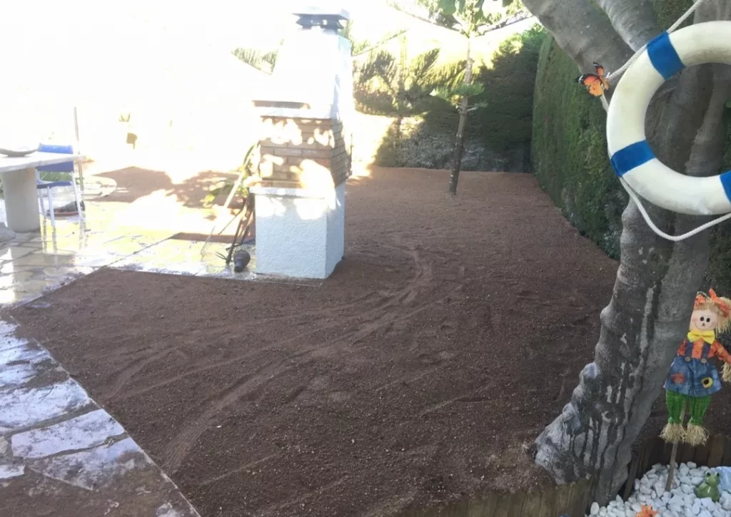 Superficie de tierra nivelada y preparada junto a un árbol con un salvavidas colgado
